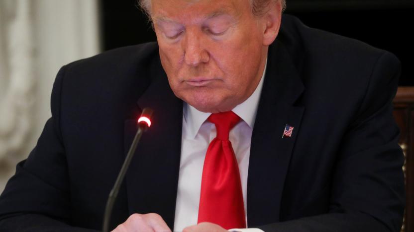 U.S. President Donald Trump uses a mobile phone during a roundtable discussion on the reopening of small businesses in the State Dining Room at the White House in Washington, U.S., June 18, 2020. REUTERS/Leah Millis