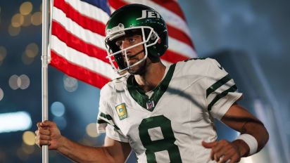 Getty Images - EAST RUTHERFORD, NEW JERSEY - SEPTEMBER 11: Aaron Rodgers #8 of the New York Jets runs onto the field with an American flag during player introductions prior to an NFL football game against the Buffalo Bills at MetLife Stadium on September 11, 2023 in East Rutherford, New Jersey. (Photo by Ryan Kang/Getty Images)