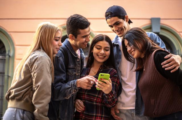 Teenager friends using the mobile phone outdoors