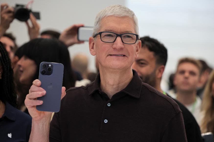 Apple CEO Tim Cook holds the new iPhone 14 at an Apple event at their headquarters in Cupertino, California, U.S. September 7, 2022. REUTERS/Carlos Barria