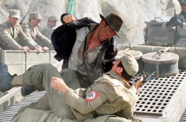 American actor Harrison Ford as the eponymous archaeologist in a scene from the film 'Indiana Jones and the Last Crusade', 1989. Here, he has a fistfight with a German soldier atop a moving tank. (Photo by Murray Close/Getty Images)