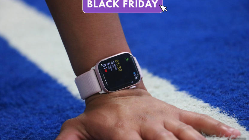 The Apple Watch Series 9 on a person's wrist, with the hand placed on a blue-and-white track. A text overlay reads "Black Friday."