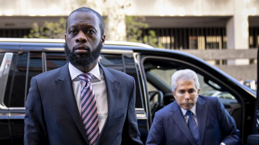 Prakazrel “Pras” Michel, left, a member of the 1990s hip-hop group the Fugees, accompanied by defense lawyer David Kenner, right, arrives at federal court for his trial in an alleged campaign finance conspiracy, Thursday, March 30, 2023, in Washington. (AP Photo/Andrew Harnik)