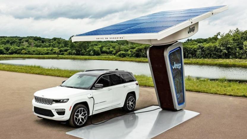 A fully electric 4xe Jeep parked at a charging station by the water.