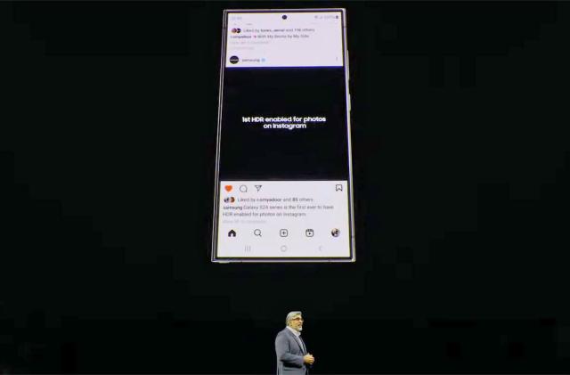 A Samsung Galaxy S24 displays an Instagram feed entry stating it's the "...first HDR enabled for photos on Instagram" on a large screen above a presenter's head at Samsung's Unpacked 2024 event.