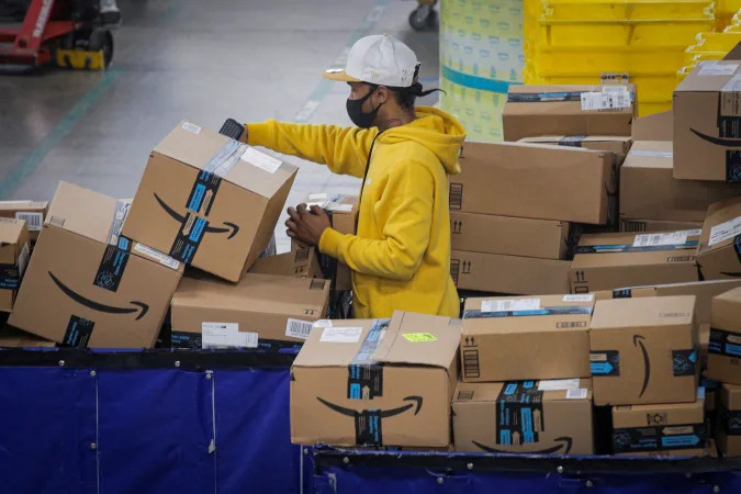 An employee scans packages at Amazon's JFK8 distribution center in Staten Island, New York, U.S. November 25, 2020. REUTERS/Brendan McDermid.