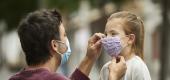 A father and his daughter wear masks outside. (Getty Images)