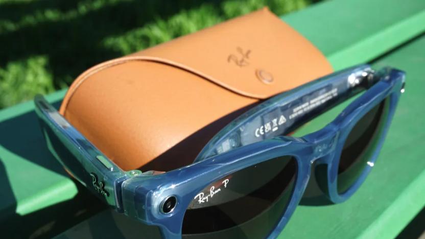 A paid of sunglasses propped against its case on a green bench.