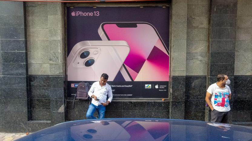 People are seen in front of an iPhone 13 advertisement , outside a store in Kolkata , India , on 29 October 2021 . Apple CEO has announced that the company has gained 29% in sales in last quarter , owing to festive season in India . (Photo by Debarchan Chatterjee/NurPhoto via Getty Images)