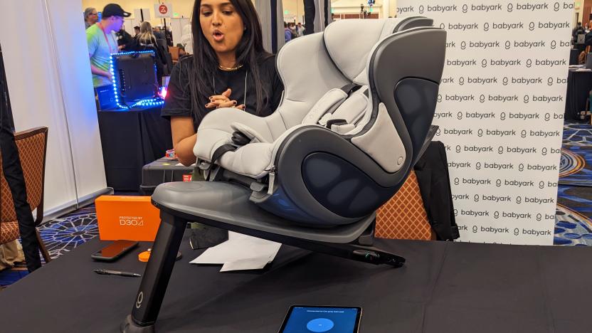 The Babyark children's car seat uses sensor-laden anticrash materials to keep your kids safe in auto wrecks. It's displayed here at a small table during CES 2023 with a Babyark representative behind it discussing the product.