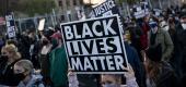 Demonstrators march south past perimeter security gates during a protest over the fatal shooting of Daunte Wright during a traffic stop. (AP)