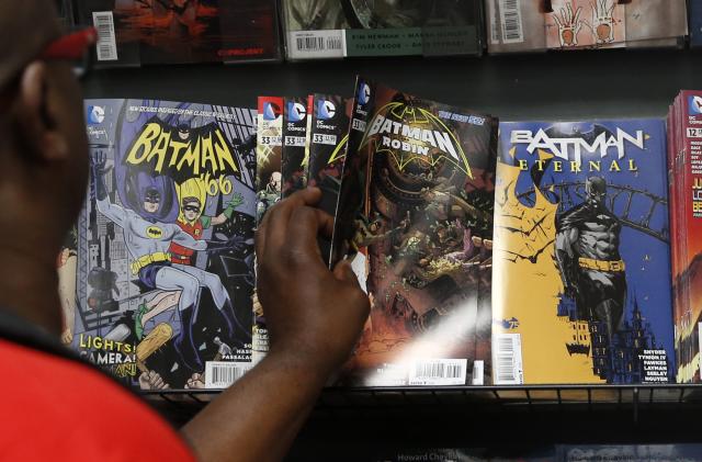 A man reaches for a Batman comic book during Batman Day at the Midtown Comics store in New York July 23, 2014. Comic book stores are celebrating the 75th anniversary of the creation of the Caped Crusader.   REUTERS/Shannon Stapleton (UNITED STATES - Tags: SOCIETY ENTERTAINMENT)