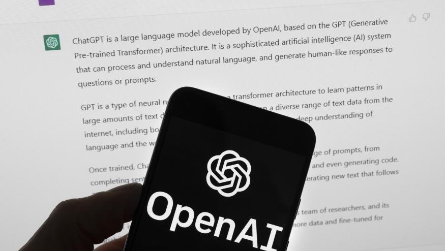 El logotipo de OpenAI puede apreciarse en un teléfono celular frente a la pantalla de una computadora que muestra los resultados de una búsqueda en Chat GPT, el 21 de marzo de 2023, en Boston. (AP Foto/Michael Dwyer, Archivo)