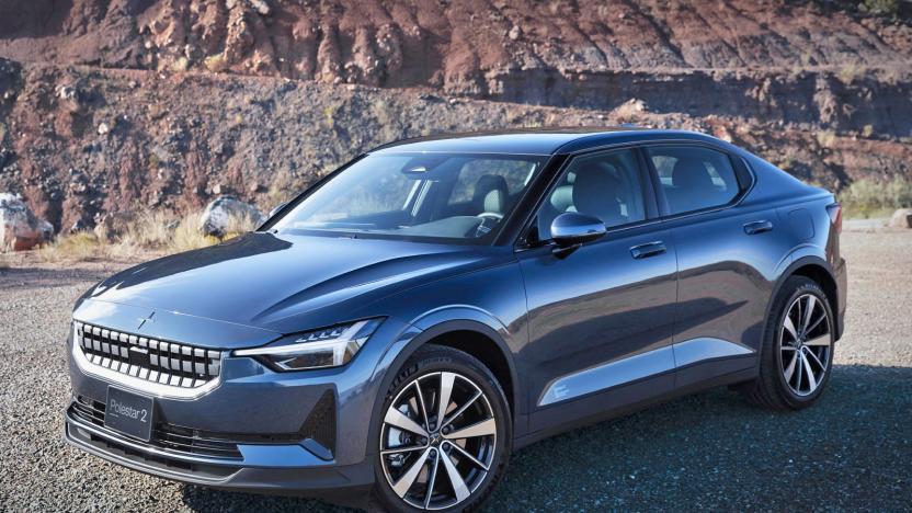 A Polestar 2 EV parked on a rocky road with stone and dirt cliffs in the background.