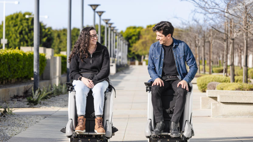 Two people sitting on high-tech chairs in the park.