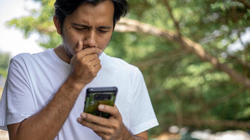 Young Asian Man coughing and covering mouth and using smartphone , take care of your Health concept , Health care concept