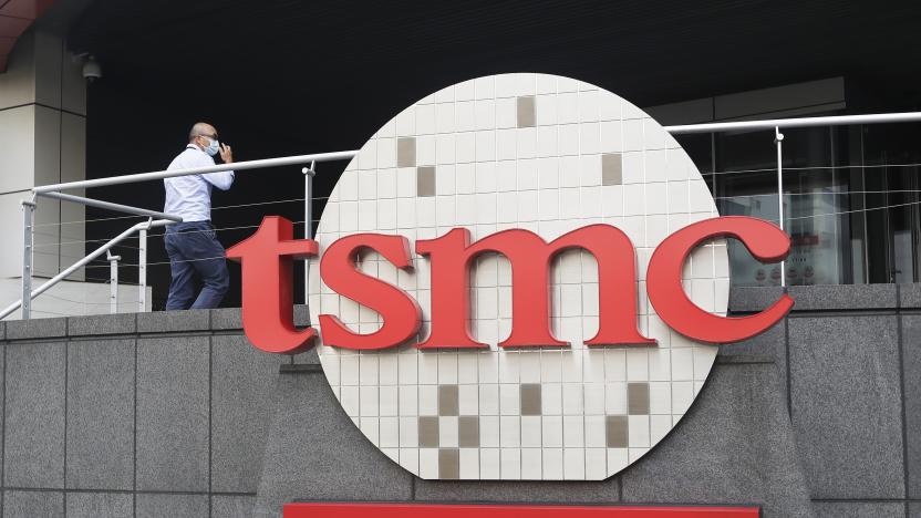 FILE - A person walks into the Taiwan Semiconductor Manufacturing Co., Ltd. (TSMC) headquarters in Hsinchu, Taiwan on Oct. 20, 2021. Taiwan Semiconductor Manufacturing Co., the biggest contract manufacturer of processor chips for smartphones and other products, said Thursday, Oct. 13, 2022, quarterly profit rose 79.7% over a year earlier to $8.8 billion amid surging demand. (AP Photo/Chiang Ying-ying, File)