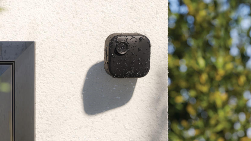 Image of Blink's Outdoor Camera 4, attached to a white rendered concrete wall covered in water droplets from a recent shower. 