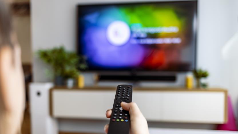 Hand with remote control in front of the tv