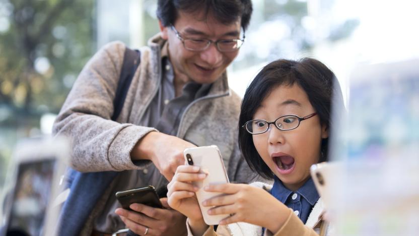 TOKYO, JAPAN - NOVEMBER 03:  A girl reacts as she tries an iPhone X at the Apple Omotesando store on November 3, 2017 in Tokyo, Japan. Apple launched the latest iPhone featuring face recognition technology, a large 5.8-inch edge-to-edge high resolution OLED display and better front and back cameras with optical image stabilisation today. (Photo by Tomohiro Ohsumi/Getty Images)