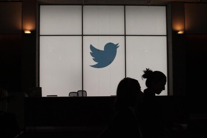 Employees walk past a lighted Twitter log as they leave the company's headquarters in San Francisco on August 13, 2019. - Twitter on August 13 said that by the end of the year users will be able to follow a small number of interests the same way they follow people. The feature will be rolled out internationally as the one-to-many messaging platform makes a priority of being an online venue for conversations rather than a pulpit for one-way broadcasting to the masses. (Photo by Glenn CHAPMAN / AFP)        (Photo credit should read GLENN CHAPMAN/AFP via Getty Images)