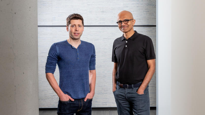 A man with brown hair in blue shirt next to a man in black shirt.