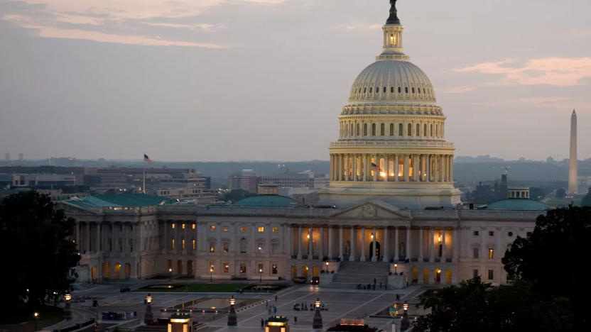 The US Capitol building illuminated against the darkening sky.