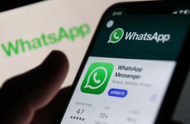WhatsApp on App Store displayed on a phone screen and WhatsApp logo displayed on a screen in the background are seen in this illustration photo taken in Krakow, Poland on Auguust 13, 2023. (Photo by Jakub Porzycki/NurPhoto via Getty Images)