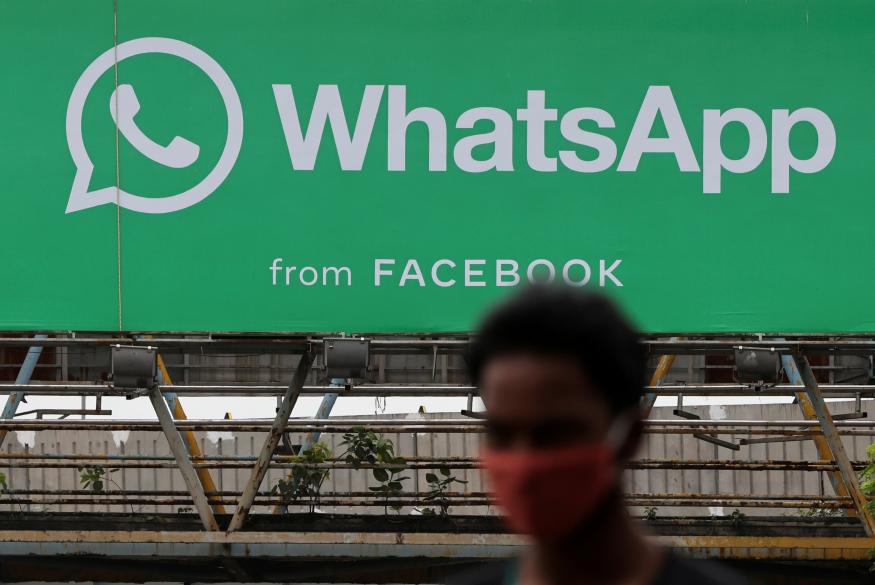 A man walks past a hoarding of the WhatsApp application installed at a skywalk in Mumbai, India, August 26, 2021. REUTERS/Francis Mascarenhas