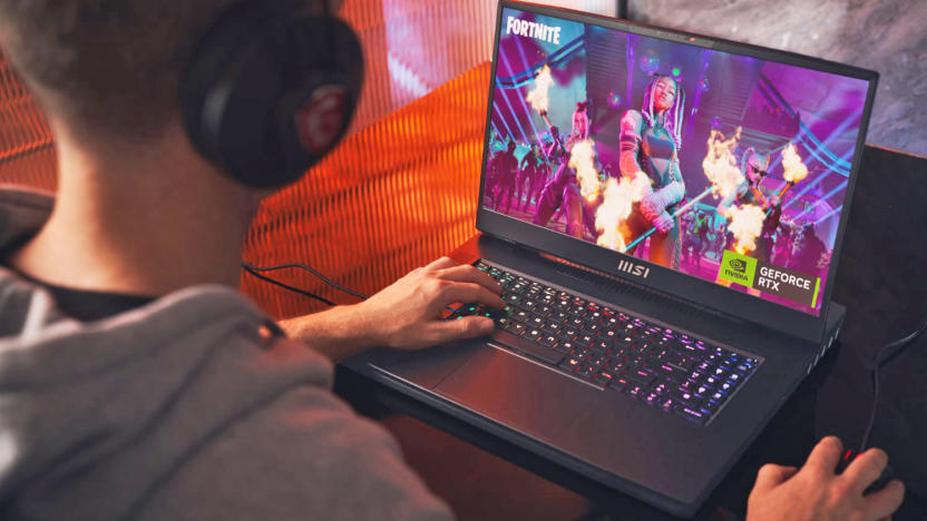 A man with gaming headphones playing 'Fortnite' on the 2023 MSI Titan GT gaming laptop.