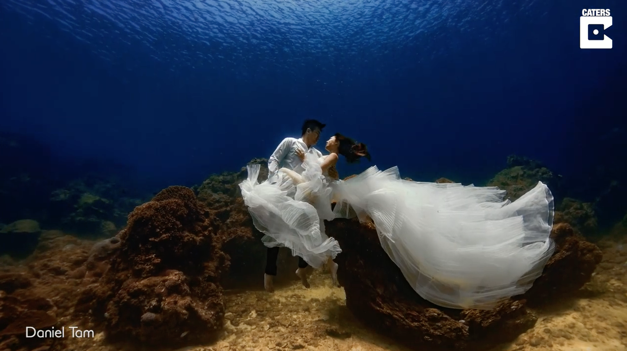 Bride and groom pose for underwater wedding shoot