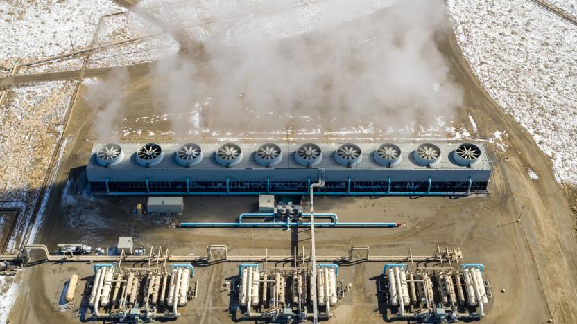 A geothermal power system showing steam rising from vents with snow surrounding it.