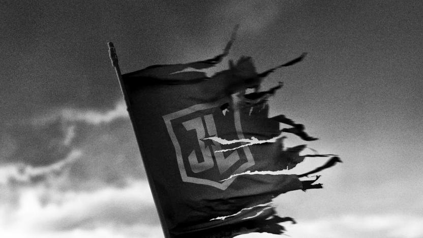 A black and white image showing a torn and tattered Justice League flag flying against a foreboding cloudy sky.