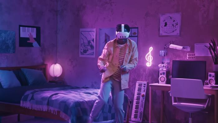 A person dancing in the middle of his room wearing a virtual reality headset.