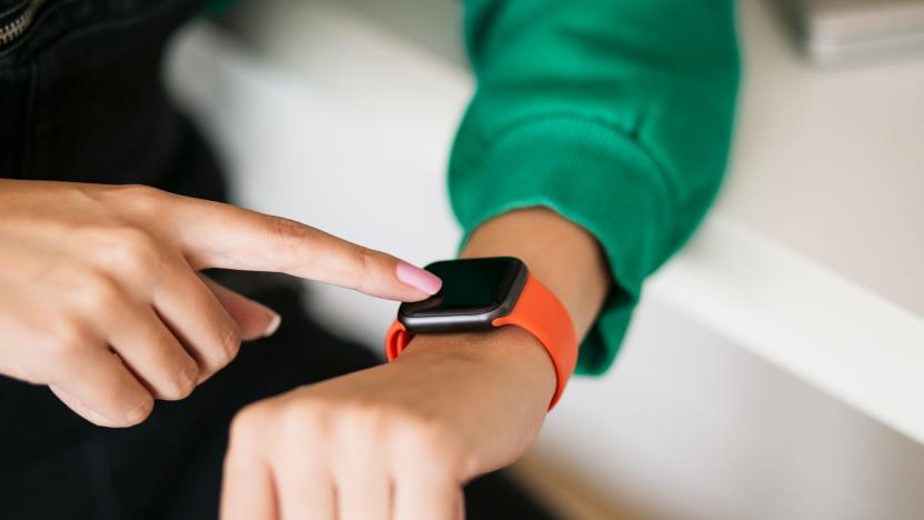 Unrecognizable Caucasian woman testing out her new smart watch at home, using it on home appliances