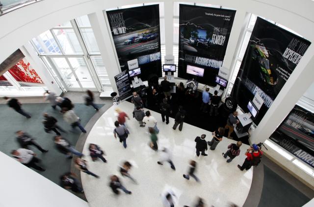 Visitors play the Electronic Arts' video game "Need for Speed Shift" as others make their way through the hallway during the Electronic Entertainment Expo or E3 in Los Angeles, June 3, 2009. The convention runs June 2-4. REUTERS/Danny Moloshok (UNITED STATES BUSINESS)