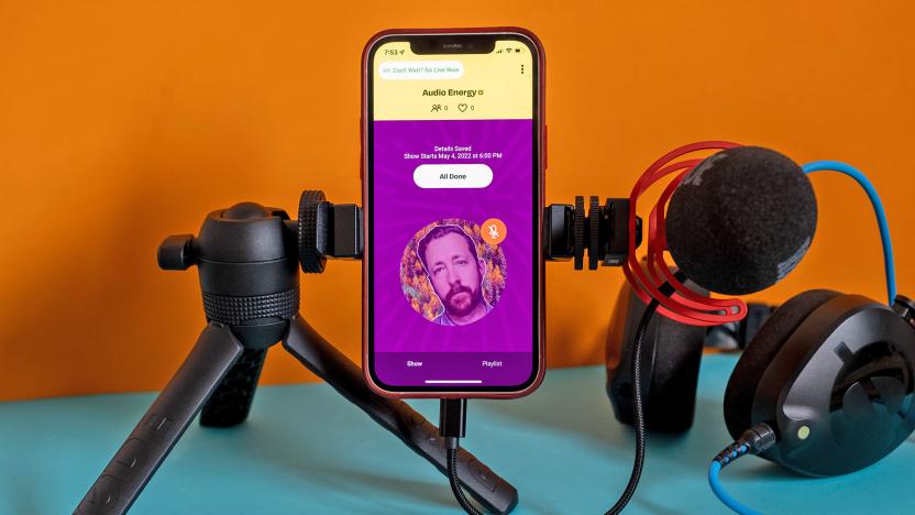 A phone showing Amazon's AMP app is connected to a boom mic and some headphones.