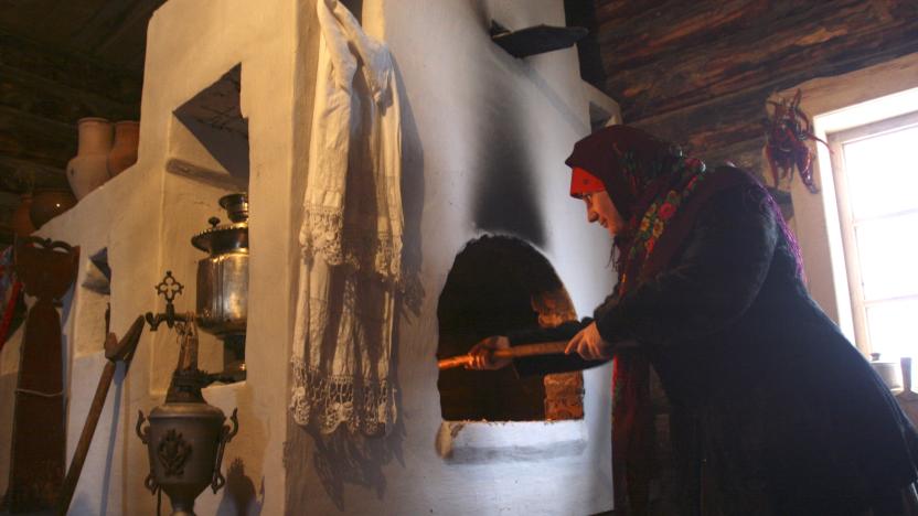 A woman cooks in a stove as part of a tourist show in a museum of traditional Russian stoves near the village of Petrovo, some 110 kilometers (68 miles) west from Moscow, December 22, 2007. Traditionally, stoves are centrepieces of rural homes and are used to warm residents in winters, prepare food and serve as heated beds. Picture taken December 22, 2007.   REUTERS/Yuri Samolygo  (RUSSIA)