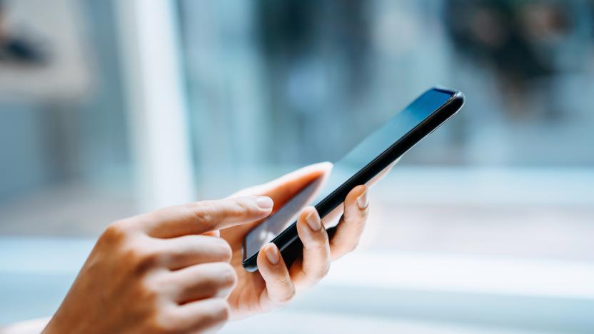 Close up of young woman using smartphone at home in sunlight