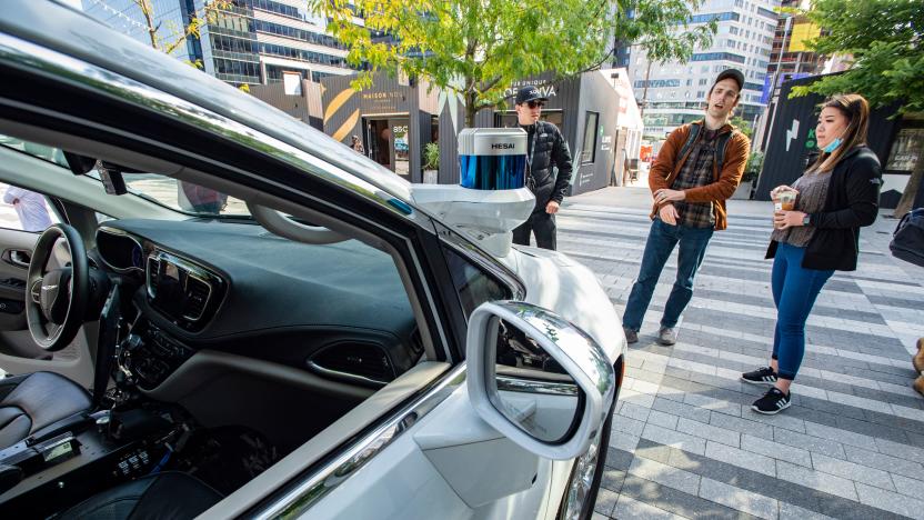 Event attendees inspect an autonomous car by Motional at the Robot Block Party put on by MassRobotoics in Boston, Massachusetts on October 2, 2021. - Leading Robotic companies showcased their latest products as well as design concepts to introduce the public to the future in robotics, from drones to autonomous cars. (Photo by Joseph Prezioso / AFP) (Photo by JOSEPH PREZIOSO/AFP via Getty Images)