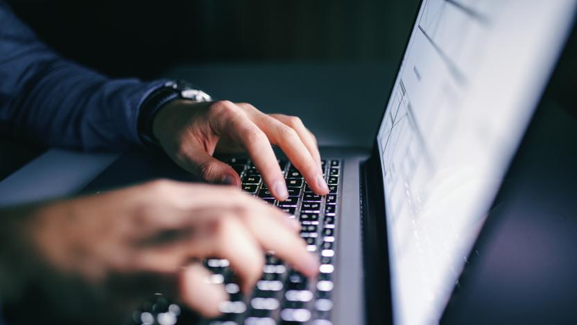 Close up of hands typing on laptop. Night work concept.