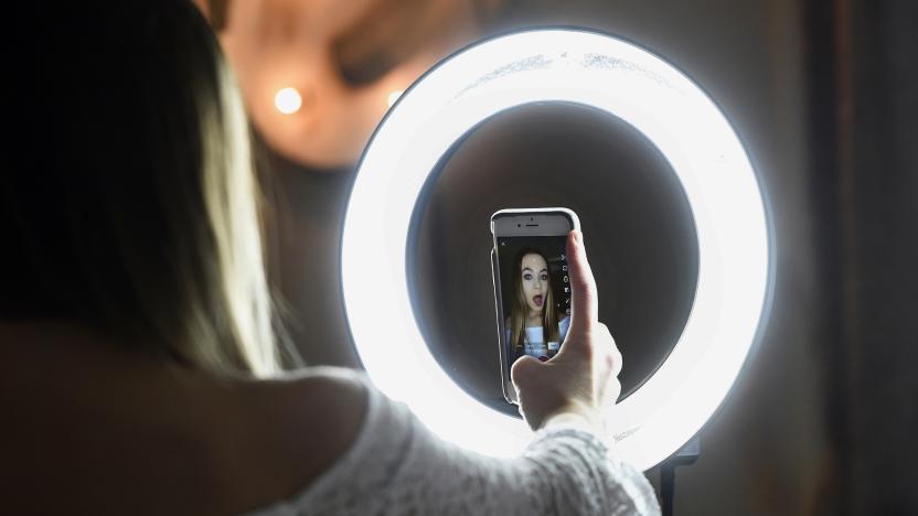 In this Feb. 28, 2018 photo, Matty Nev Luby holds up her phone in front of a ring light she uses to lip-sync with the smartphone app Musical.ly, in Wethersfield, Conn. Teens and young adults say cyberbullying is a serious problem for people their age, but most don’t think they’ll be the ones targeted for digital abuse. The high school gymnast’s popularity on the lip-syncing app Musical.ly, which merged this summer into the Chinese video-sharing app TikTok, helped win her some modeling contracts. Luby said she's learned to navigate Instagram and other social media apps by brushing aside the anonymous bullies. (AP Photo/Jessica Hill)