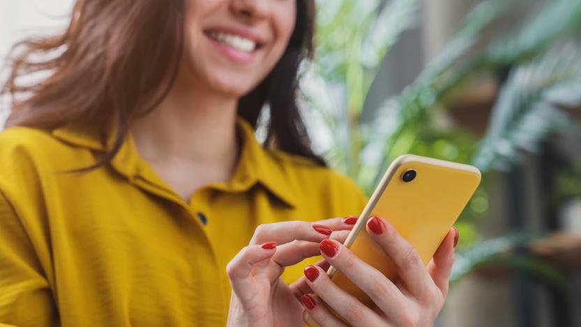 Cropped image of happy girl using smartphone device while chilling at home