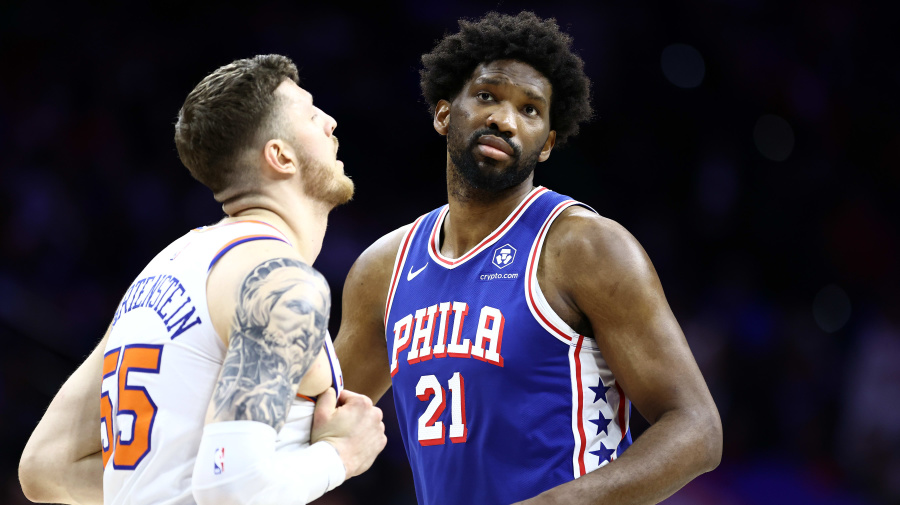 Getty Images - PHILADELPHIA, PENNSYLVANIA - APRIL 25: Joel Embiid #21 of the Philadelphia 76ers looks on past Isaiah Hartenstein #55 of the New York Knicks during the first quarter game three of the Eastern Conference First Round Playoffs at the Wells Fargo Center on April 25, 2024 in Philadelphia, Pennsylvania. NOTE TO USER: User expressly acknowledges and agrees that, by downloading and/or using this Photograph, user is consenting to the terms and conditions of the Getty Images License Agreement. (Photo by Tim Nwachukwu/Getty Images)