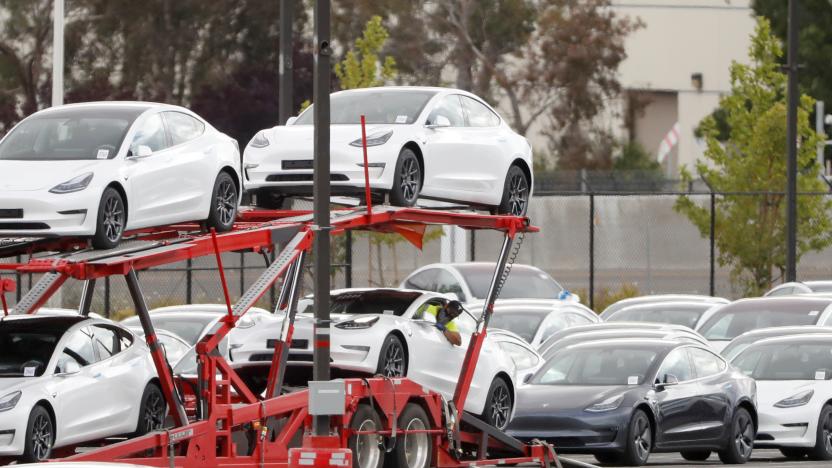 A worker loads a Tesla electric vehicle onto a car carrier trailer at Tesla's primary vehicle factory after CEO Elon Musk announced he was defying local officials' coronavirus disease (COVID-19) restrictions by reopening the plant in Fremont, California, U.S. May 11, 2020. REUTERS/Stephen Lam