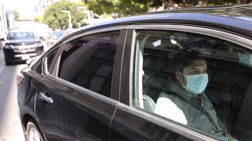 LOS ANGELES, CALIFORNIA - APRIL 16: A young passenger wears a face mask as Uber and Lyft drivers with Rideshare Drivers United and the  Transport Workers Union of America conduct a ‘caravan protest’ outside the California Labor Commissioner’s office amidst the coronavirus pandemic on April 16, 2020 in Los Angeles, California. The drivers called for California to enforce the AB 5 law so that they may qualify for unemployment insurance as the spread of COVID-19 continues. Drivers also called for receiving back wages they say they are owed. (Photo by Mario Tama/Getty Images)