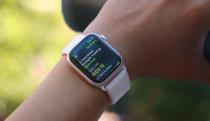 The Apple Watch Series 9 on a person's wrist, with the hand holding a black water bottle in the background. The screen shows the summary of a Functional Strength Training workout.